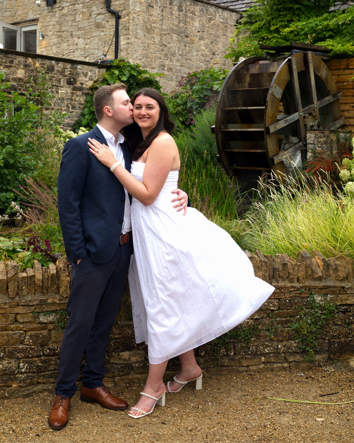 Ben and Nicole at their engagement shoot, beside an old watermill